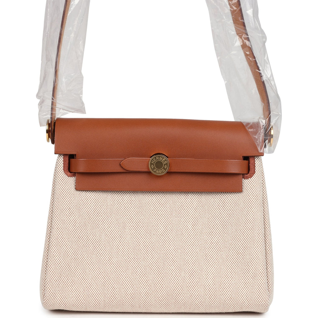 حقيبة Herbag Zip 20 ميني من قماش Toile H باللونين الإيكرو والبيج مع جلد Vache Hunter باللون الفوف وأجزاء معدنية من ذهب