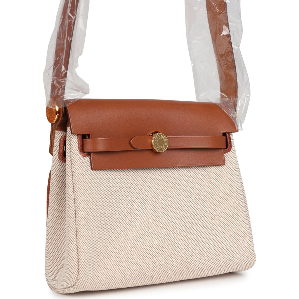 حقيبة Herbag Zip 20 ميني من قماش Toile H باللونين الإيكرو والبيج مع جلد Vache Hunter باللون الفوف وأجزاء معدنية من ذهب