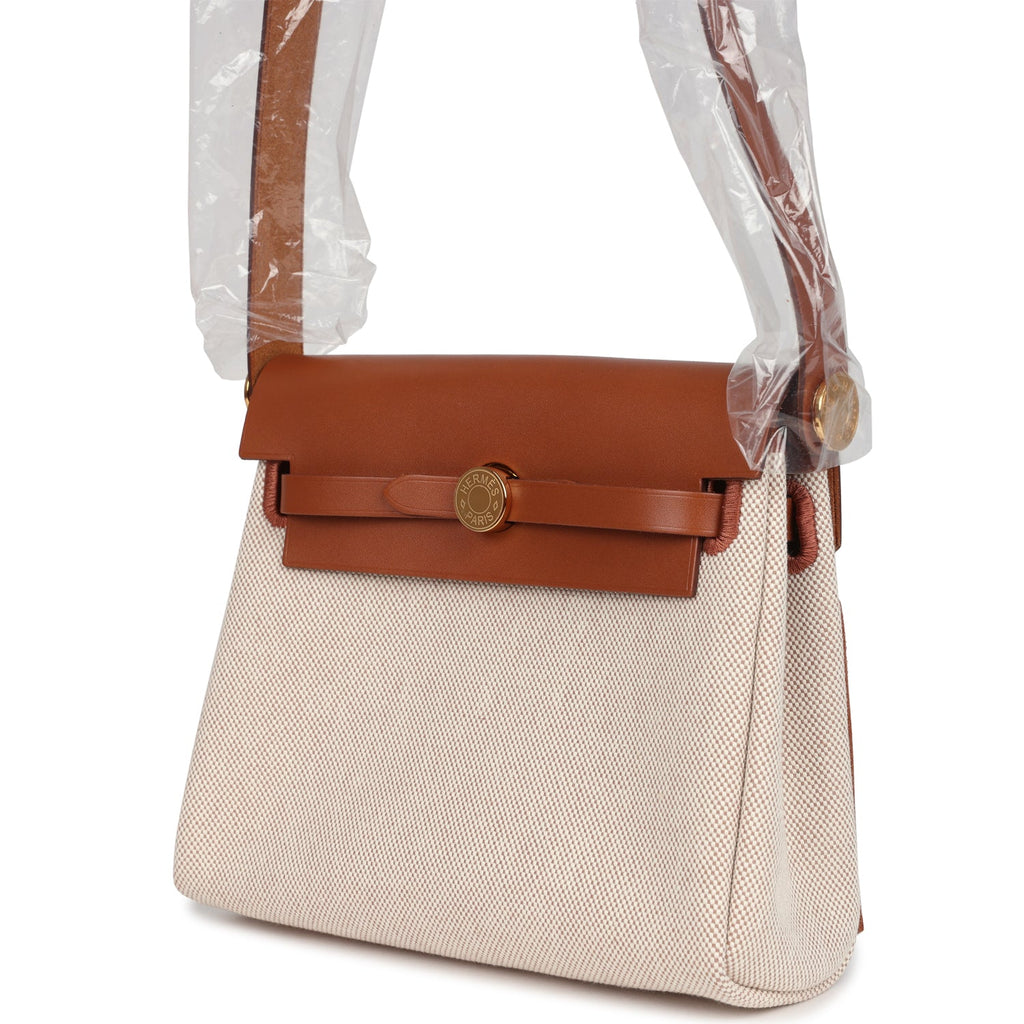 حقيبة Herbag Zip 20 ميني من قماش Toile H باللونين الإيكرو والبيج مع جلد Vache Hunter باللون الفوف وأجزاء معدنية من ذهب