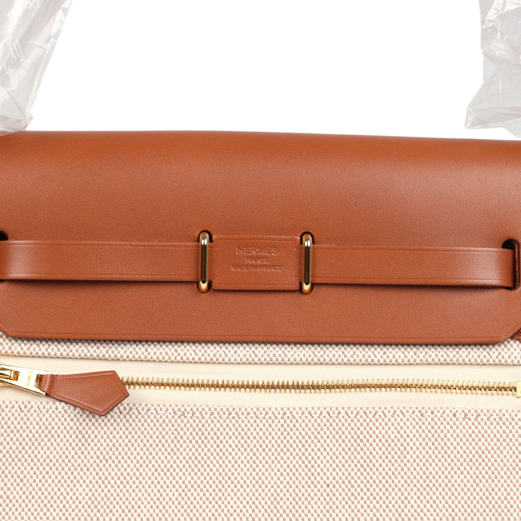 حقيبة Herbag Zip 20 ميني من قماش Toile H باللونين الإيكرو والبيج مع جلد Vache Hunter باللون الفوف وأجزاء معدنية من ذهب