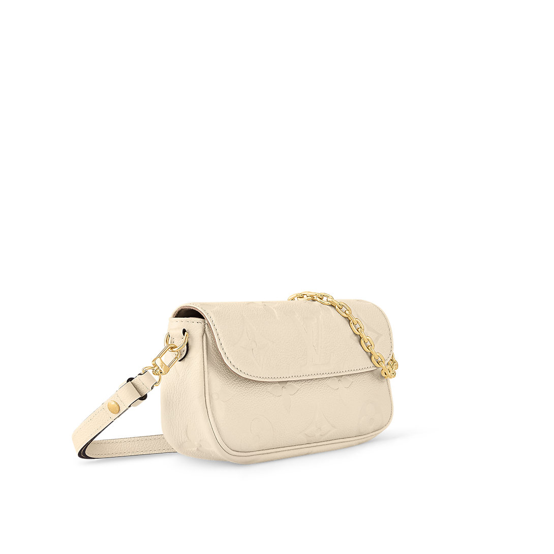 حقيبة Ivy Wallet on Chain بنقش Monogram Empreinte باللون الكريمي، تُحمل بوضعية كروس بودي